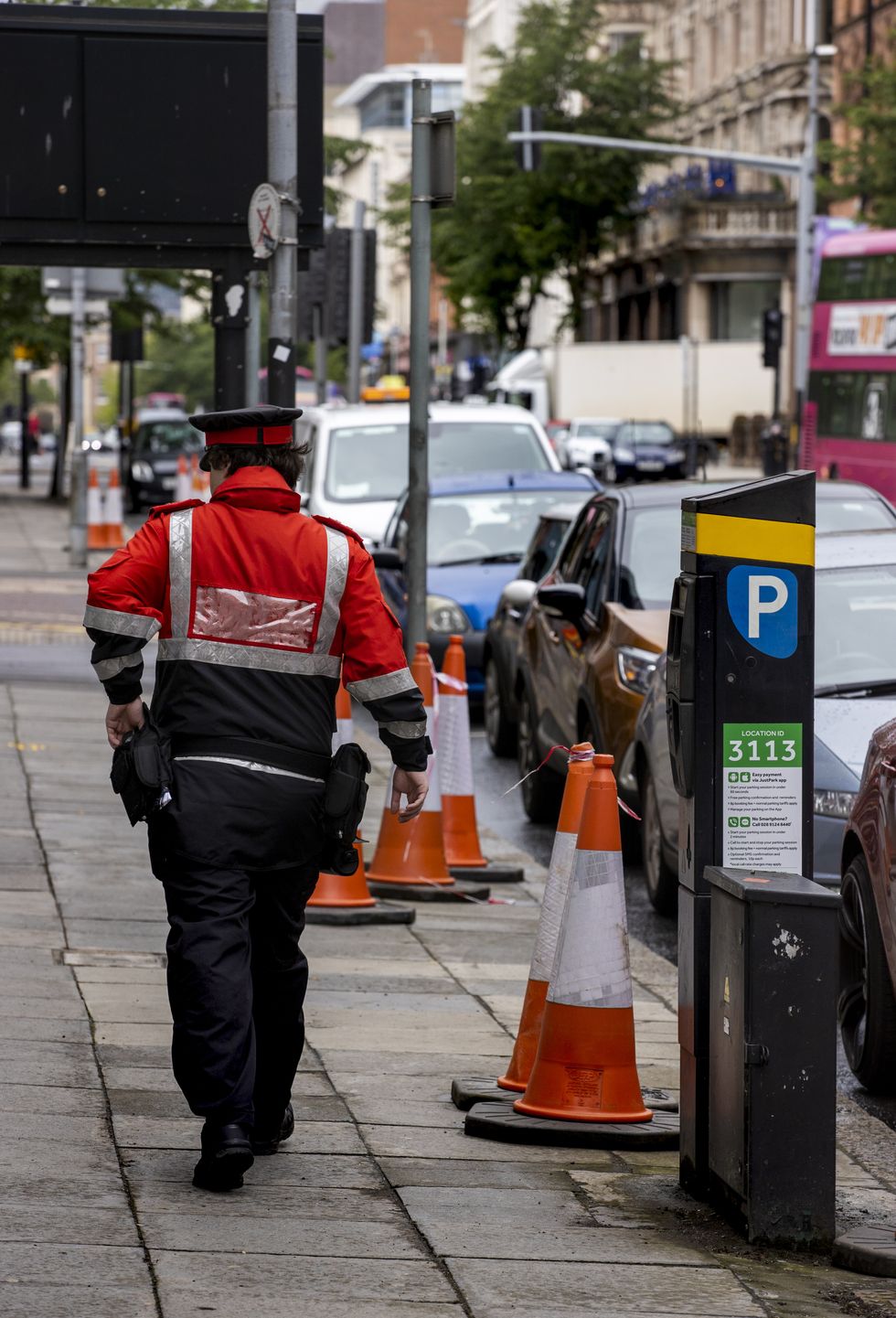 Parking inspector walking past a pay and display 