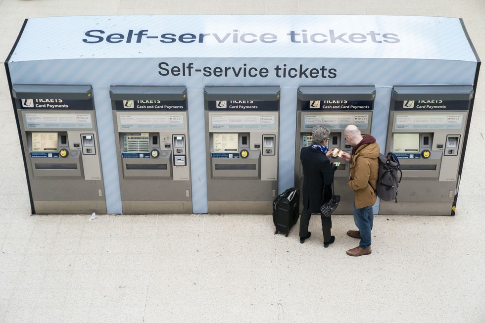 Passengers at the ticket machines in Waterloo Station train station in London