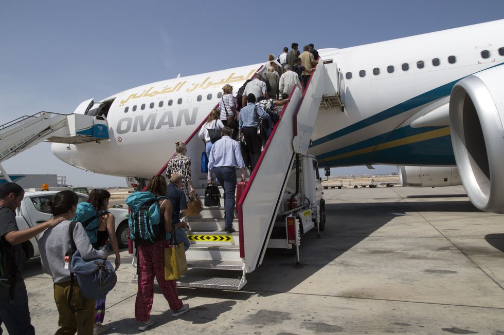 Passengers board a plane at Muscat International Airport