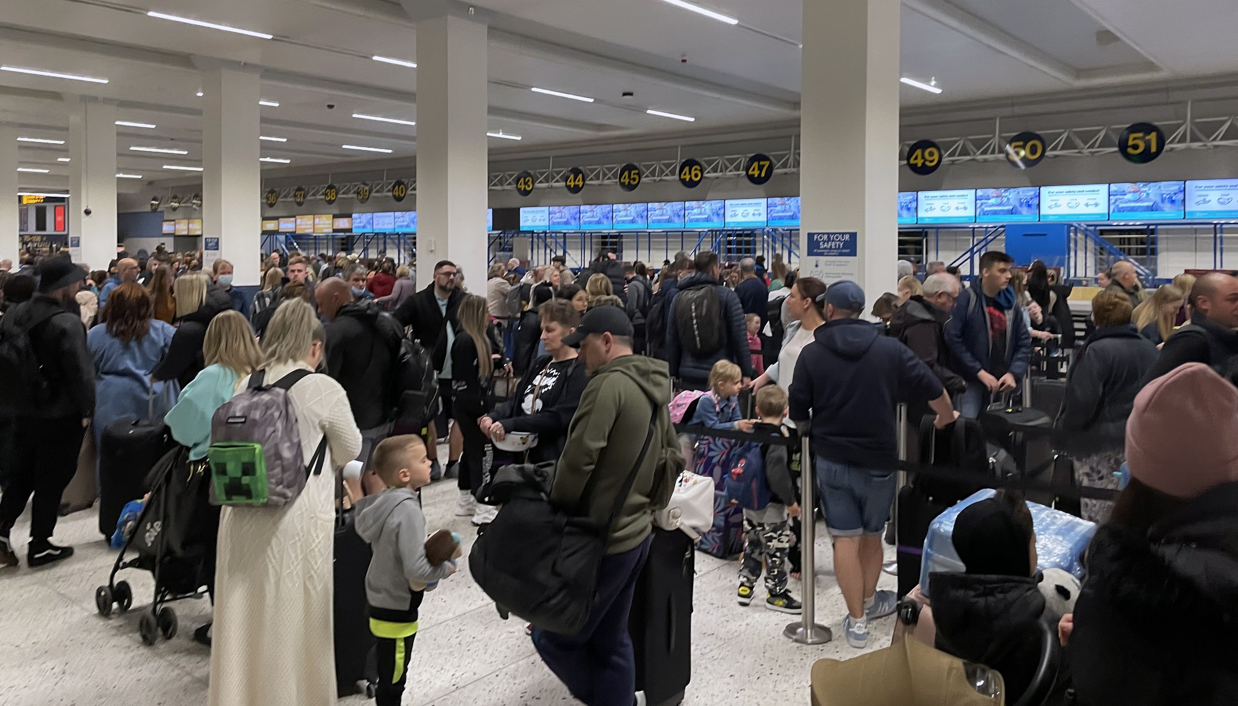 Passengers queue inside the departures area of Terminal 1 at Manchester Airport