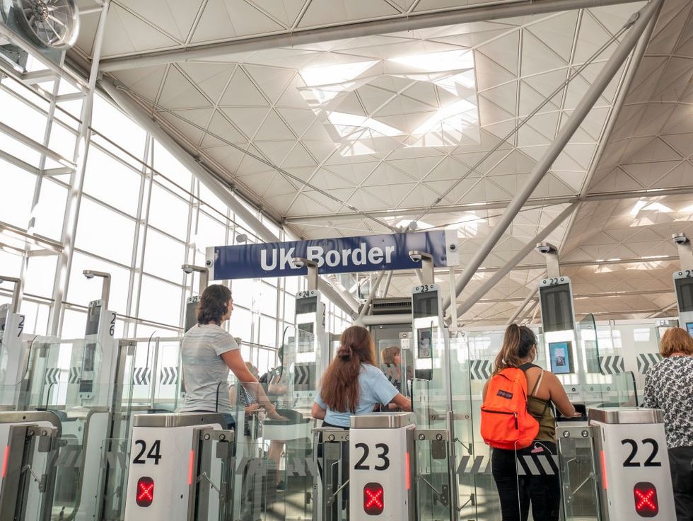 Passengers using the E-gates at UK border control, Stansted Airport