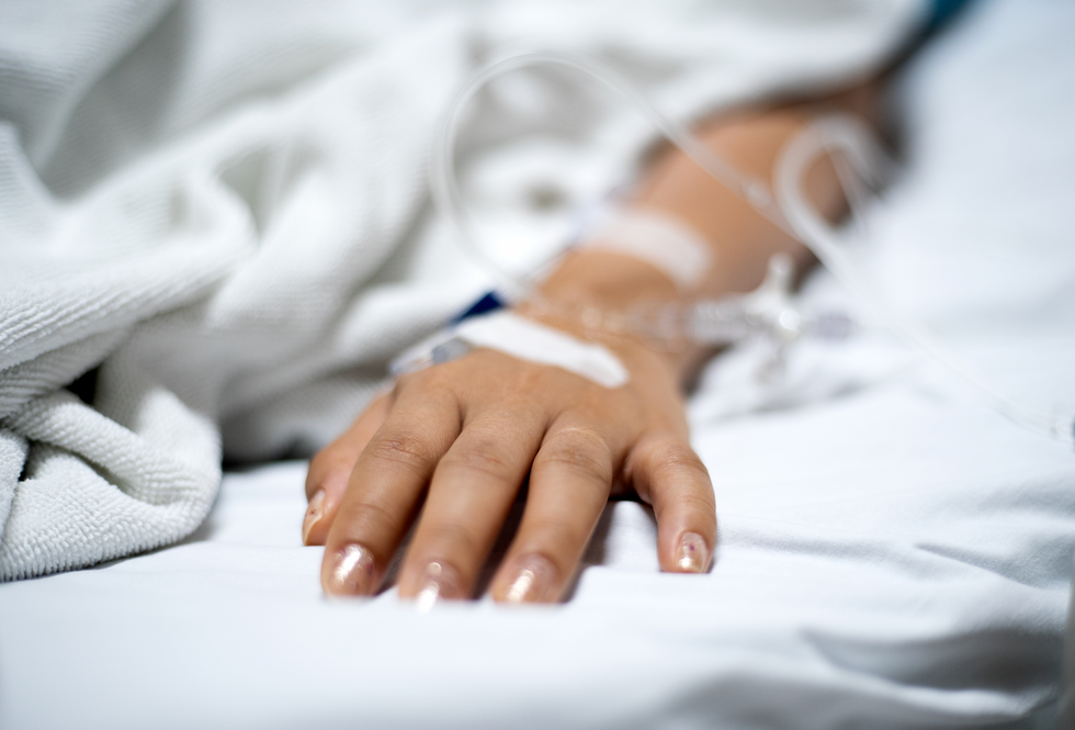 Patient's hand on a hospital bed