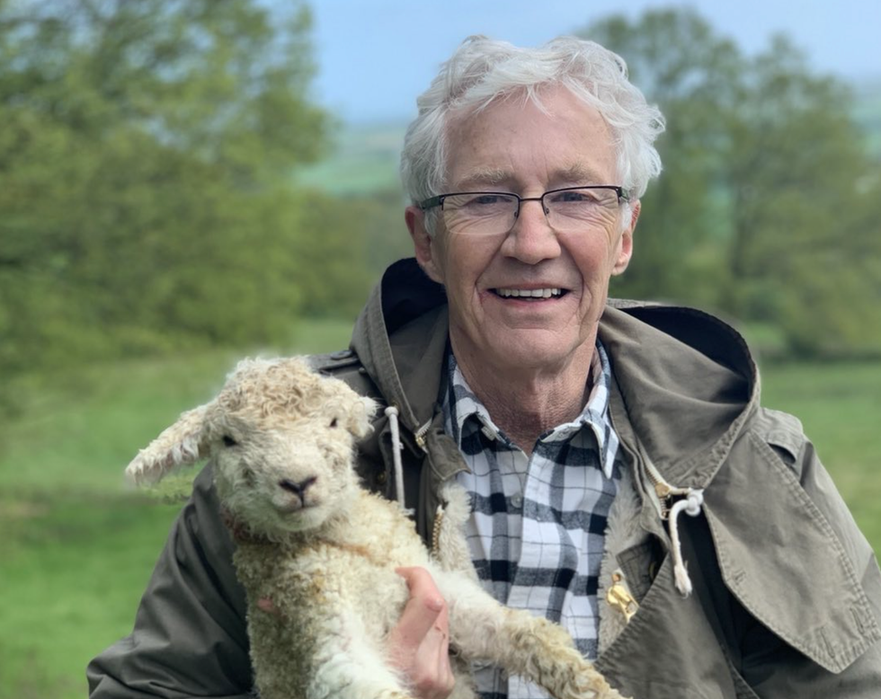 Paul O'Grady in a field with a lamb