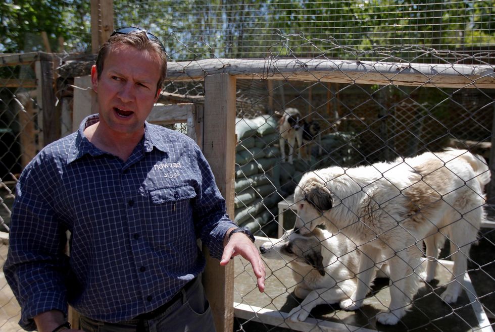 Pen Farthing, founder of animal shelter Nowzad, stands in front of a cage on the outskirts of Kabul May 1, 2012.