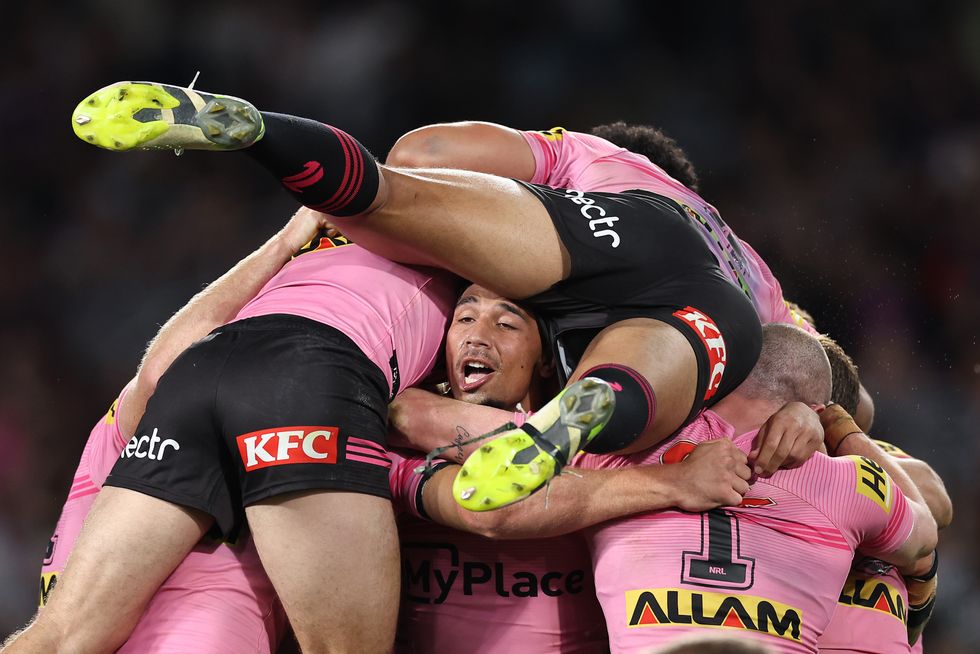 penrith players pictured jumping on one another to celebrate their victory in the NRL Grand Final
