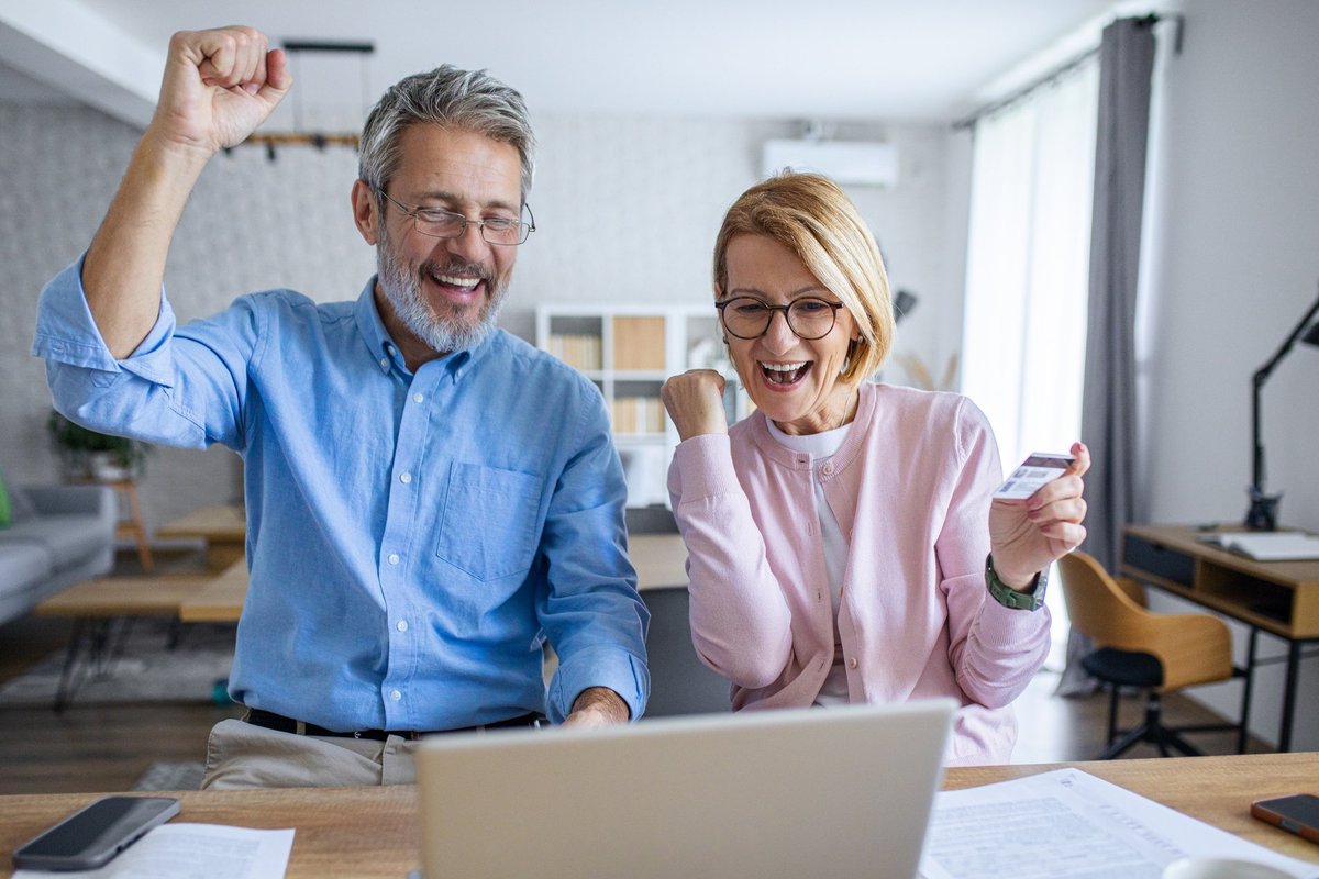 Pensioner couple happy at laptop