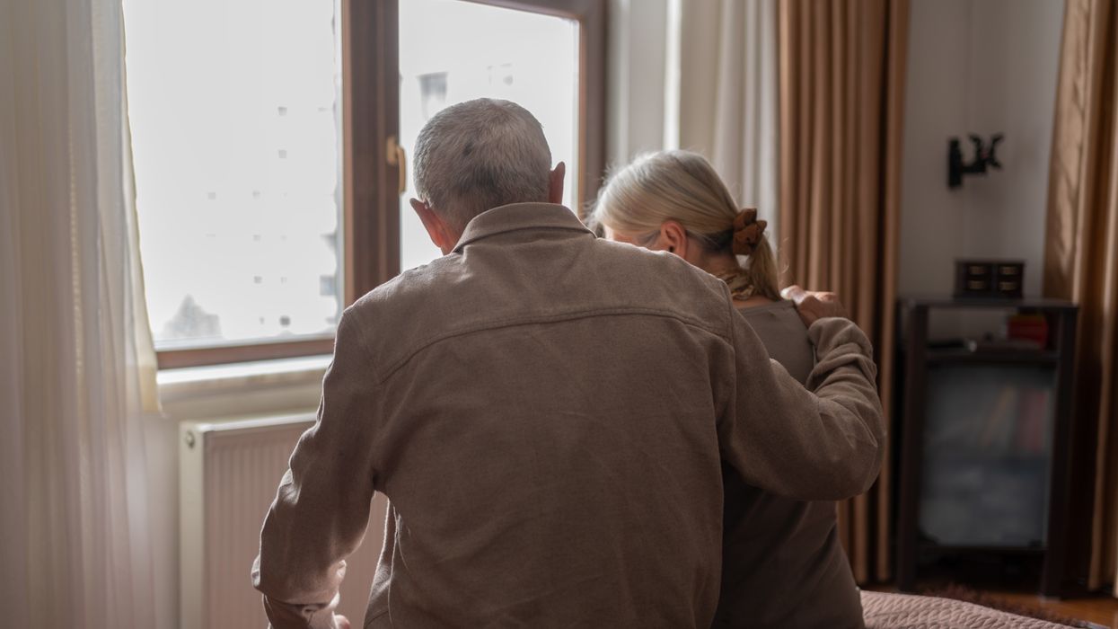Pensioner couple sit on bed