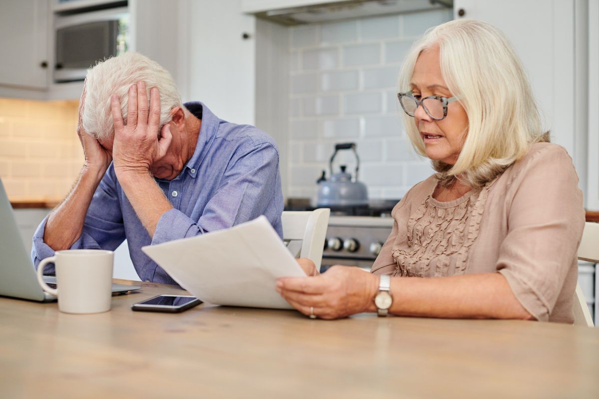 Pensioner couple worried at laptop