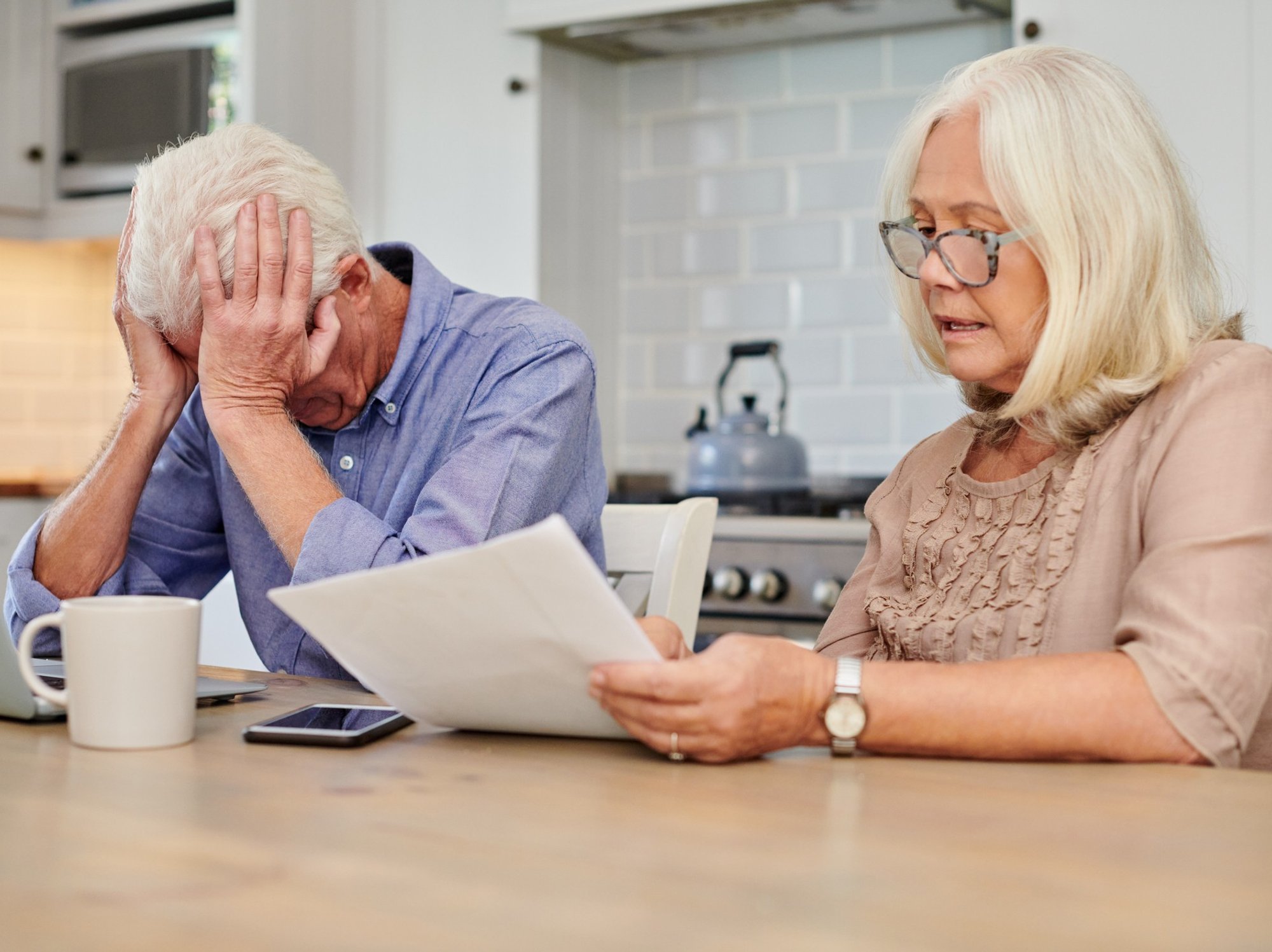 Pensioner couple worried at laptop