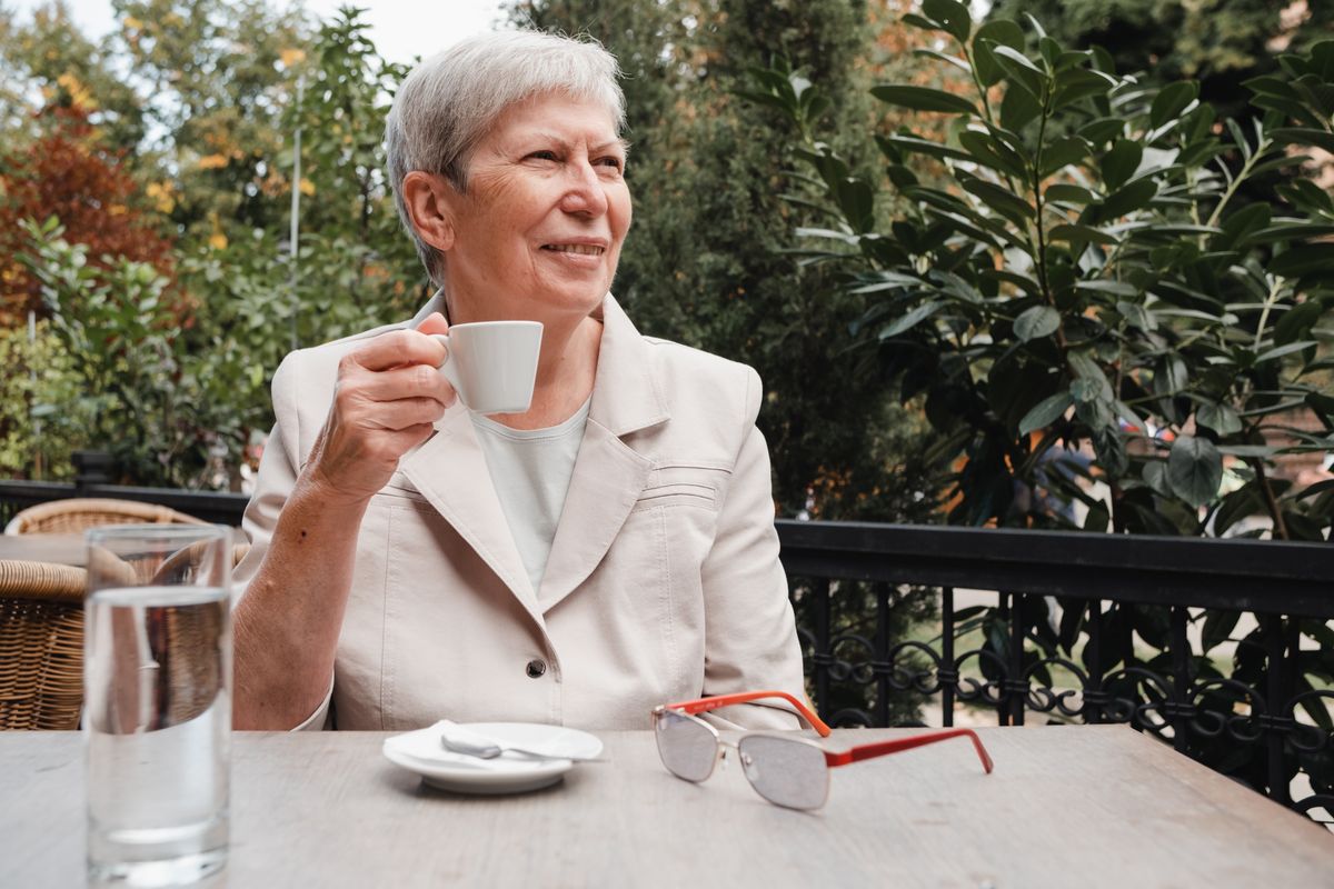 Pensioner enjoying coffee outside in retirement 