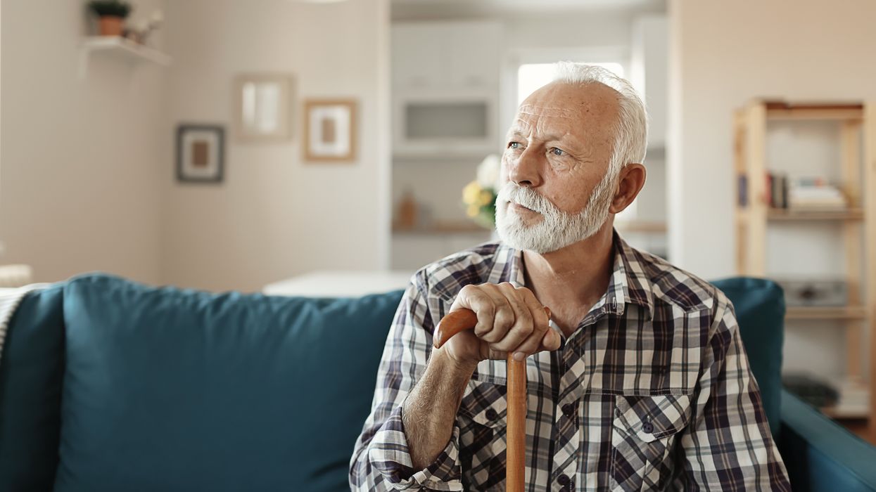 Pensioner holds walking stick in pictures