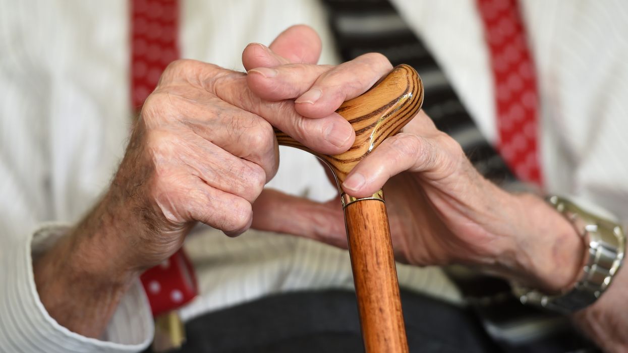 Pensioner holds walking stick