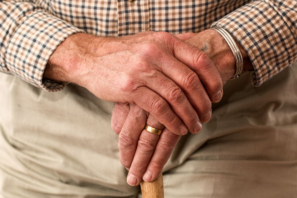 Pensioner holds walking stick