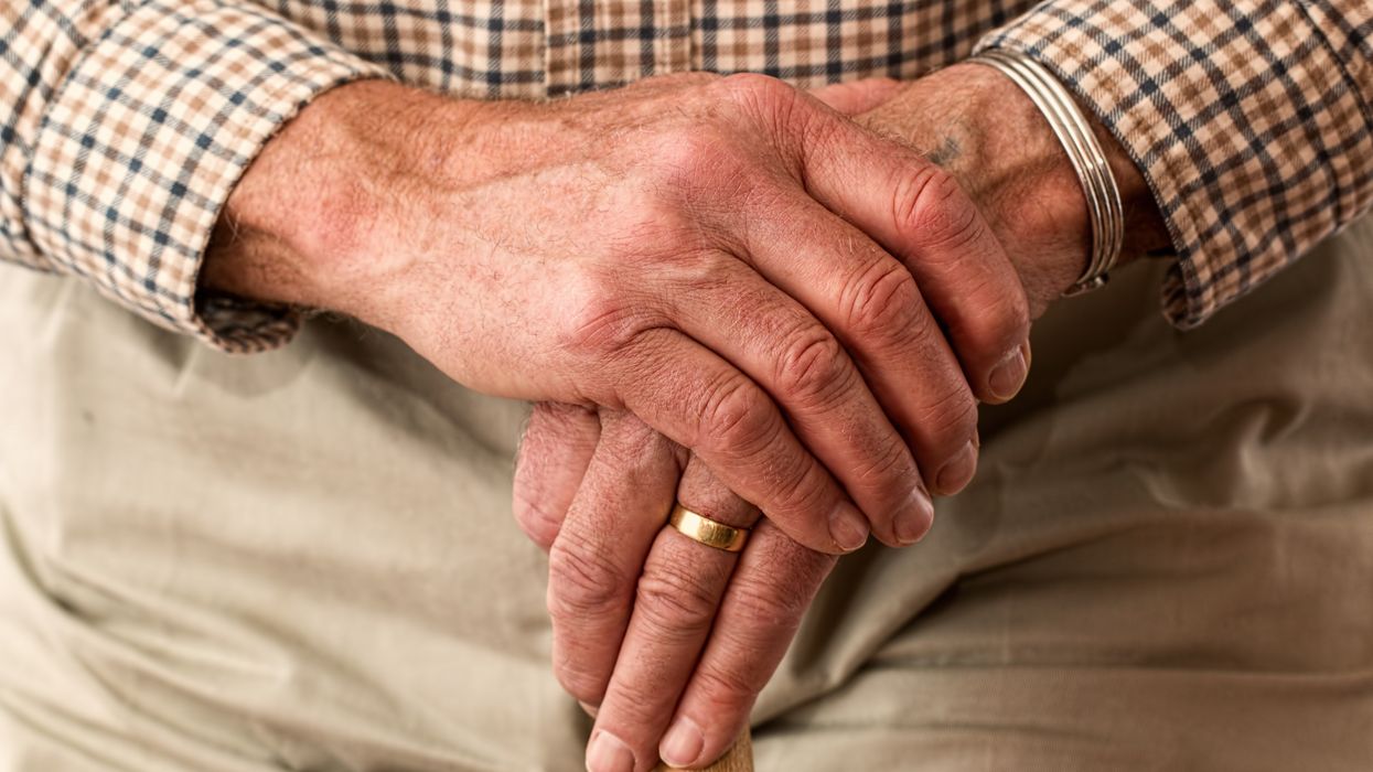 Pensioner holds walking stick