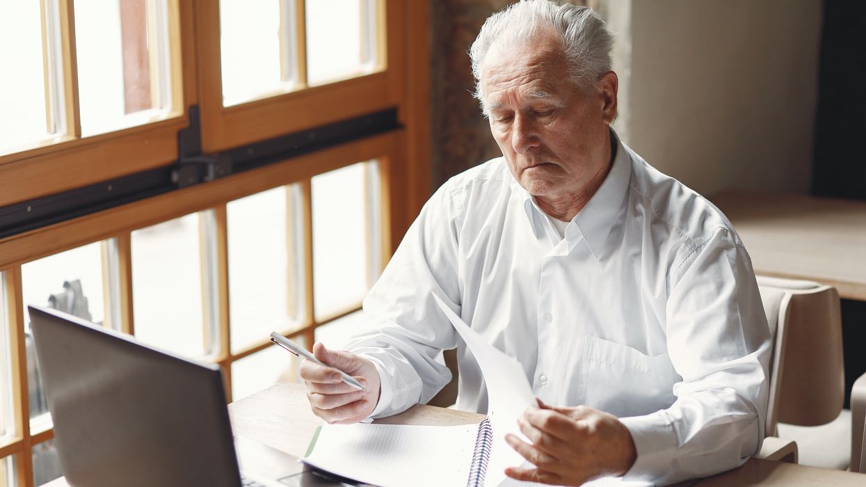 Pensioner looking at finances with laptop in front of him