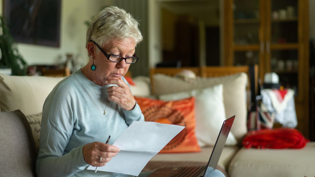 Pensioner looks at bank statement and laptop