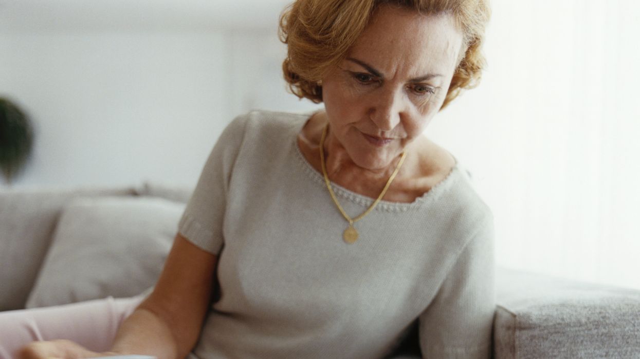 Pensioner looks at documents and calculator