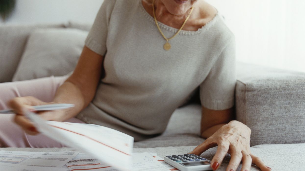 Pensioner looks at documents and calculator