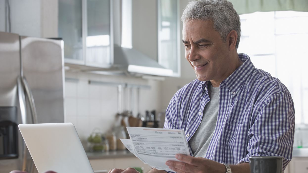 Pensioner looks at laptop and financial documents