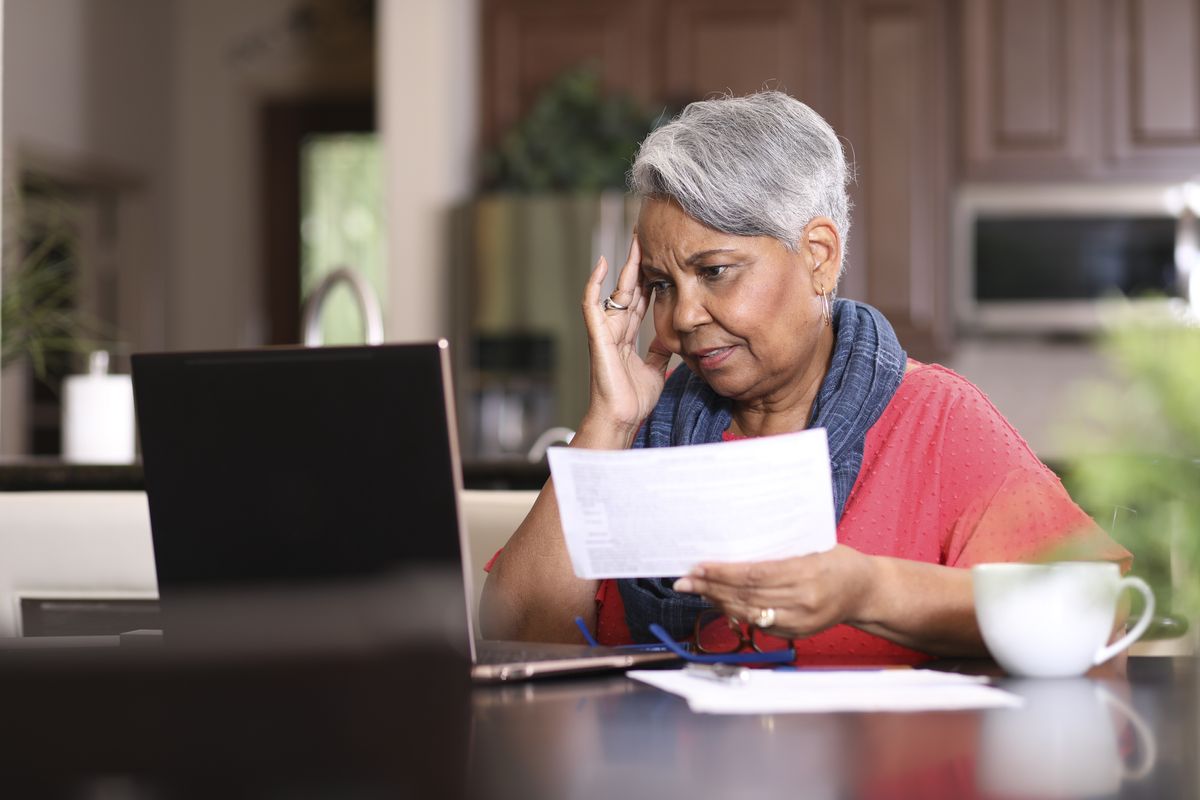 Pensioner looks at laptop and financial documents