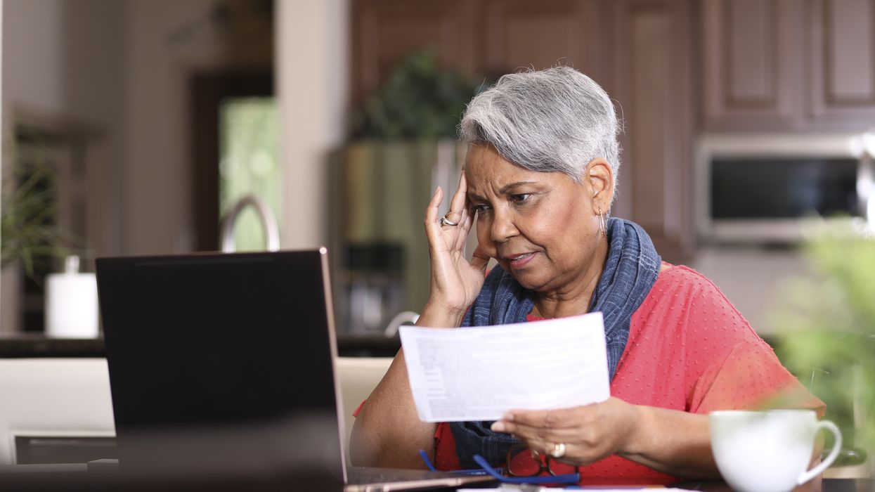 Pensioner looks at laptop and financial documents