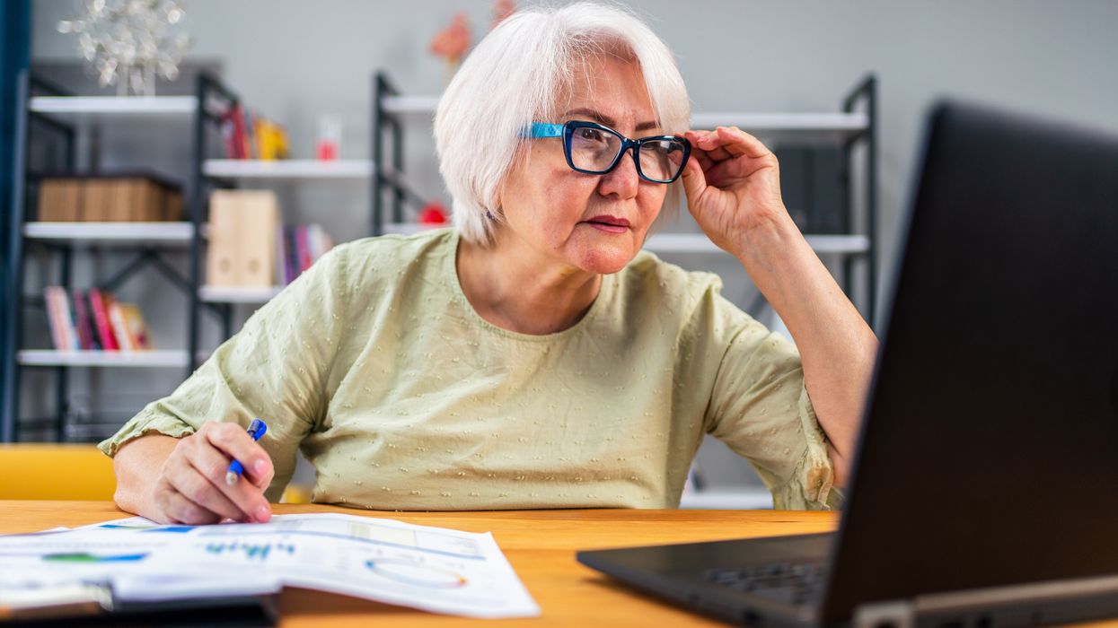 Pensioner looks at laptop while sorting finances