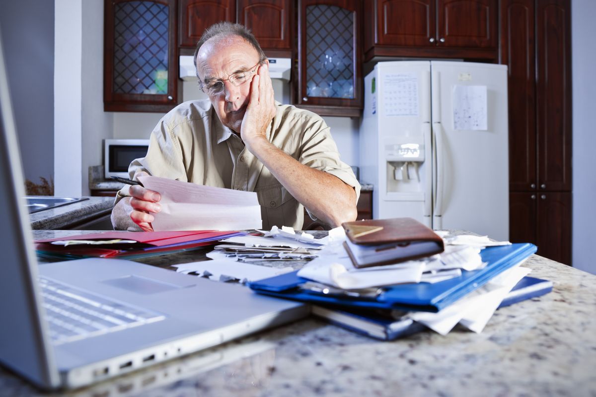 Pensioner looks at letter looking worried