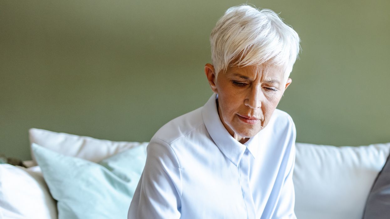 Pensioner looks at phone while sorting finances