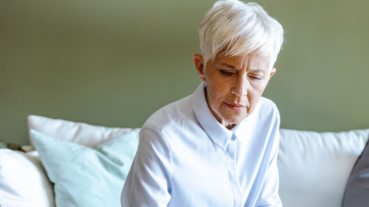 Pensioner looks at phone while sorting finances