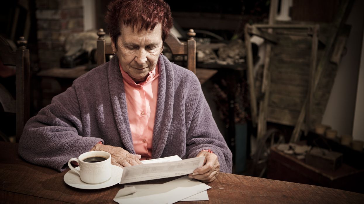 Pensioner looks worried at bills