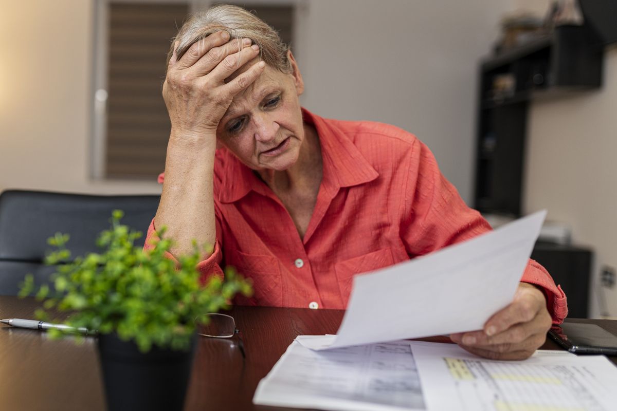 Pensioner looks worried at tax statement