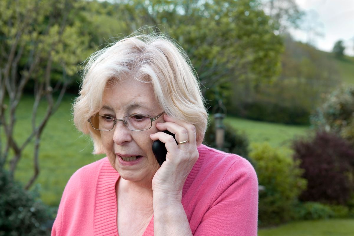 Pensioner on the phone outside