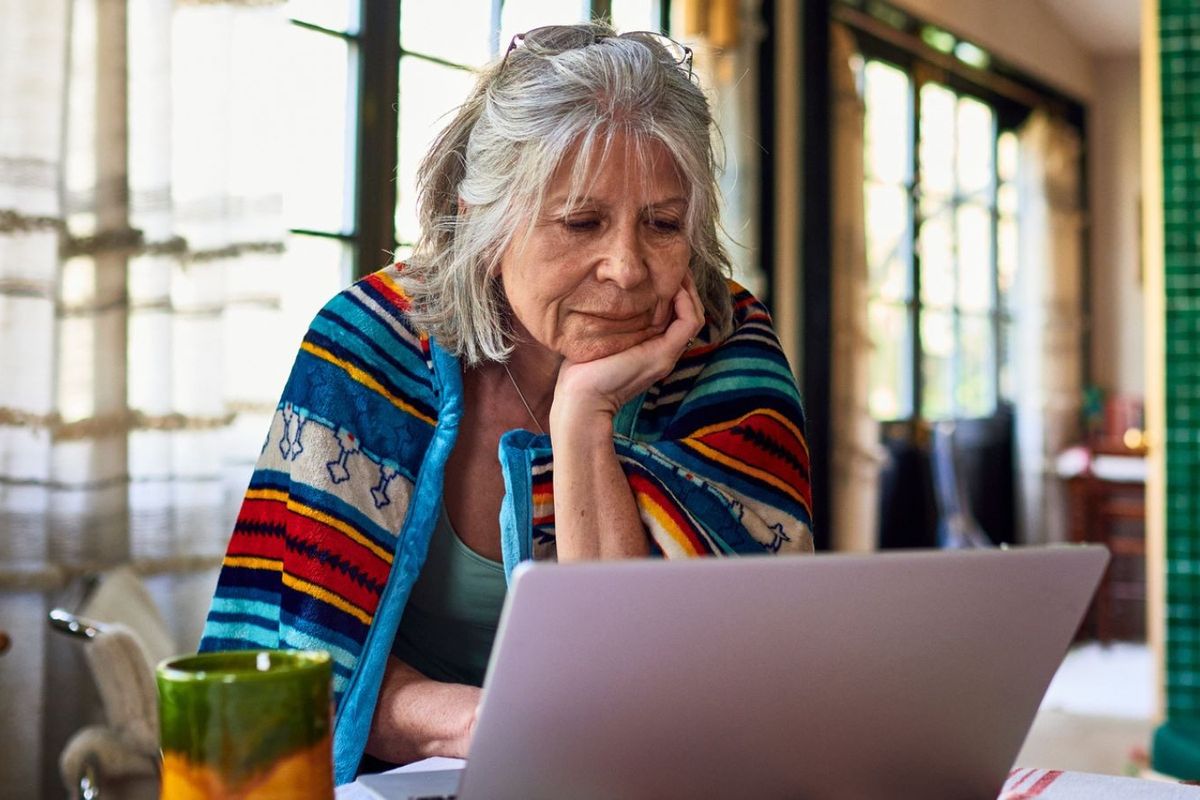 Pensioner reading at laptop
