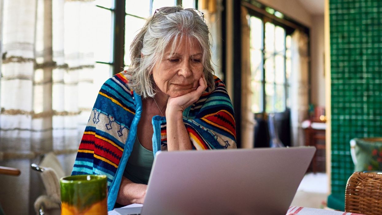 Pensioner reading at laptop