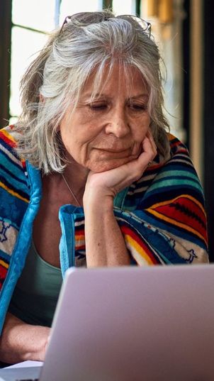 Pensioner reading at laptop