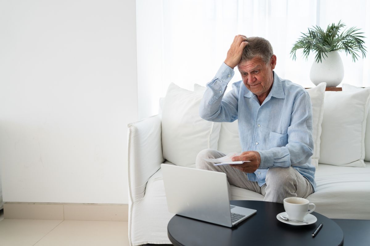 Pensioner scratches head at laptop and letter