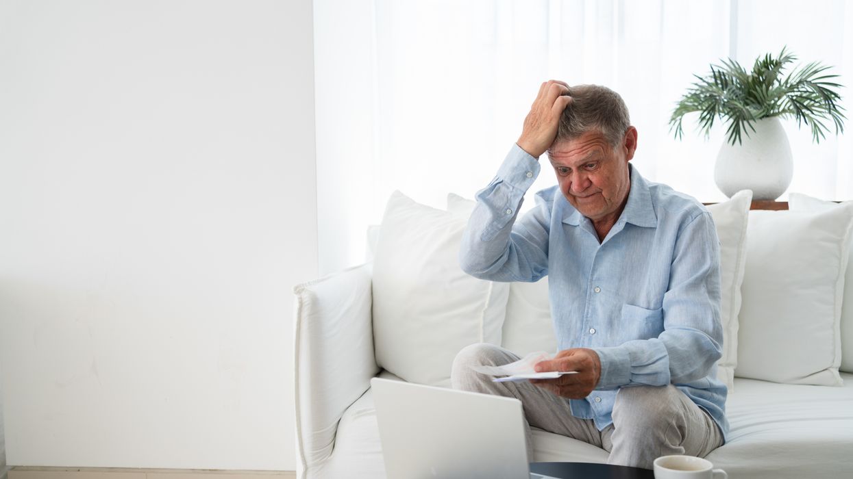 Pensioner scratches head at laptop and letter
