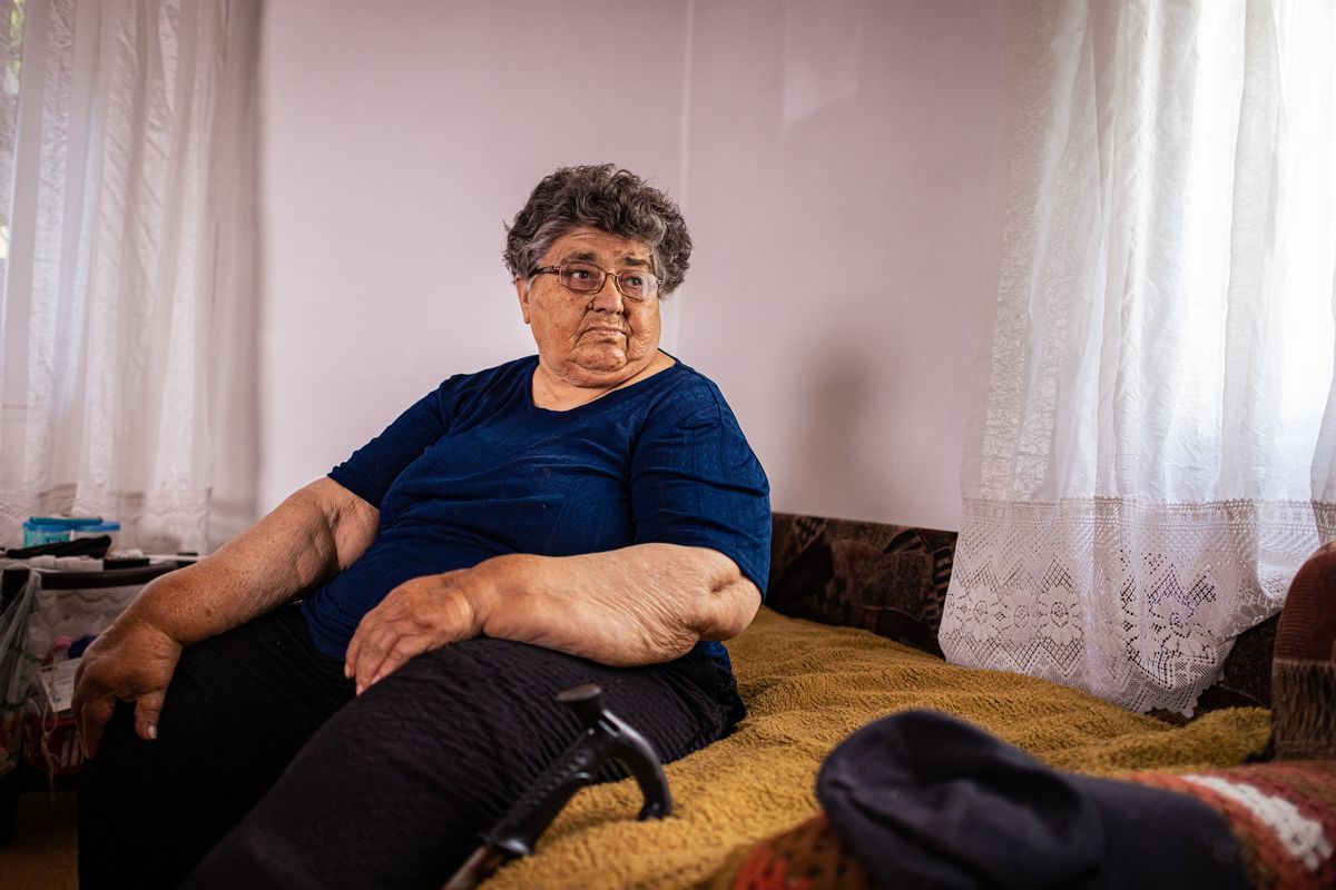 Pensioner sits on sofa in pictures