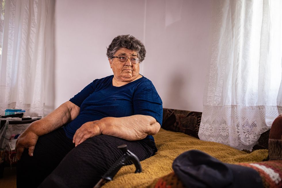 Pensioner sits on sofa in pictures