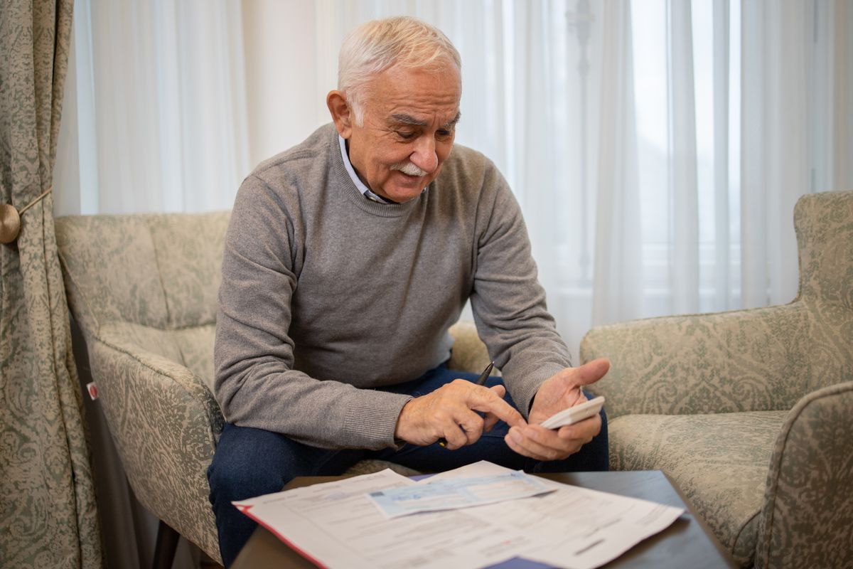 Pensioner with bank statements and calculator
