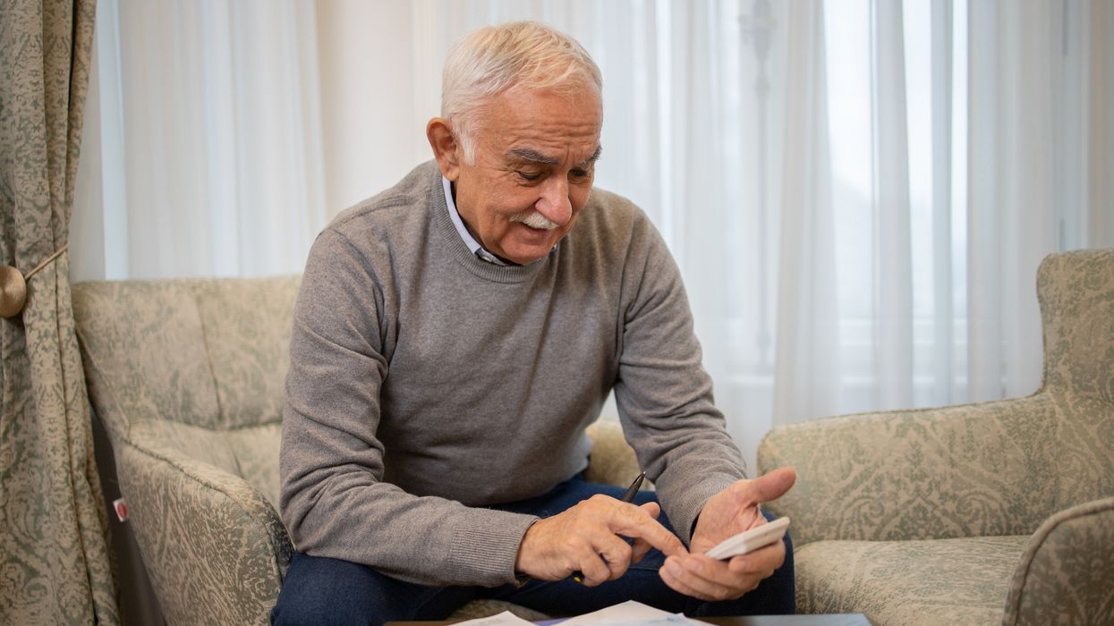 Pensioner with bank statements and calculator