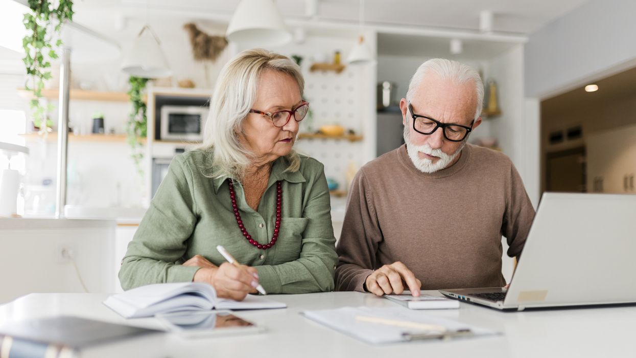 Pensioners look at calculator and laptop