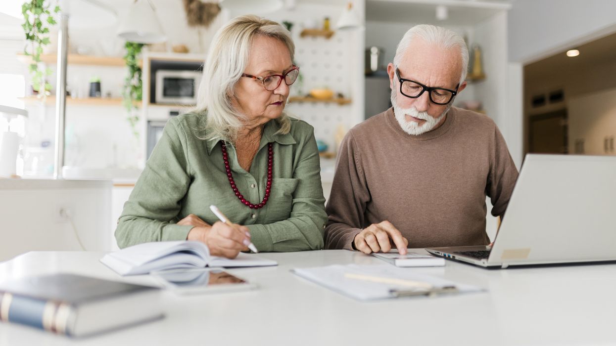 Pensioners look at calculator and laptop