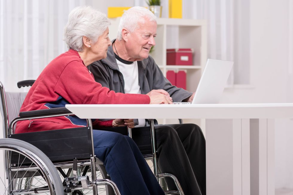 Pensioners look at laptop in pictures