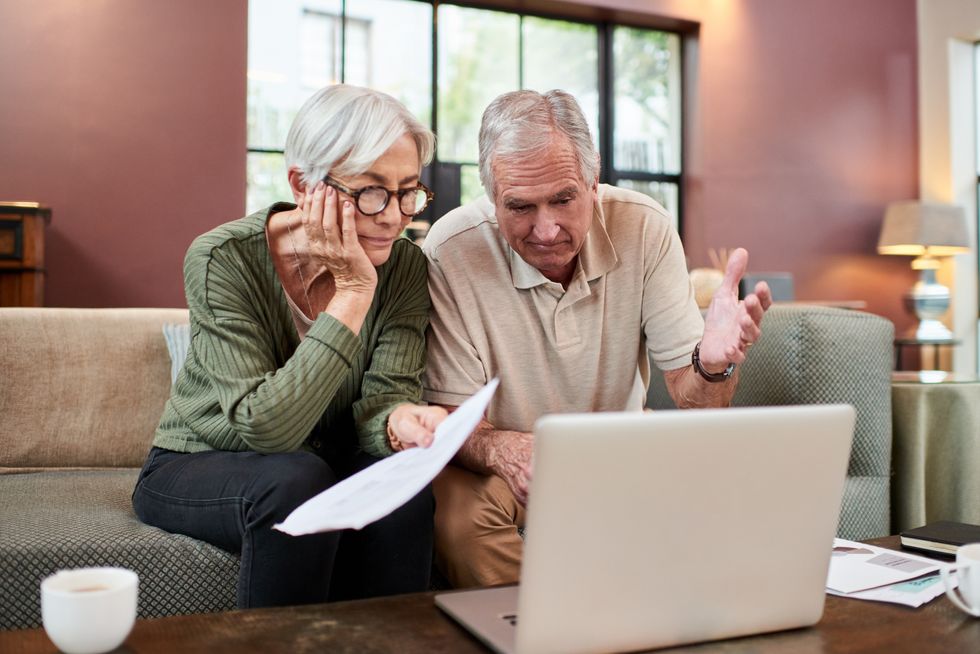 Pensioners look worried at laptop