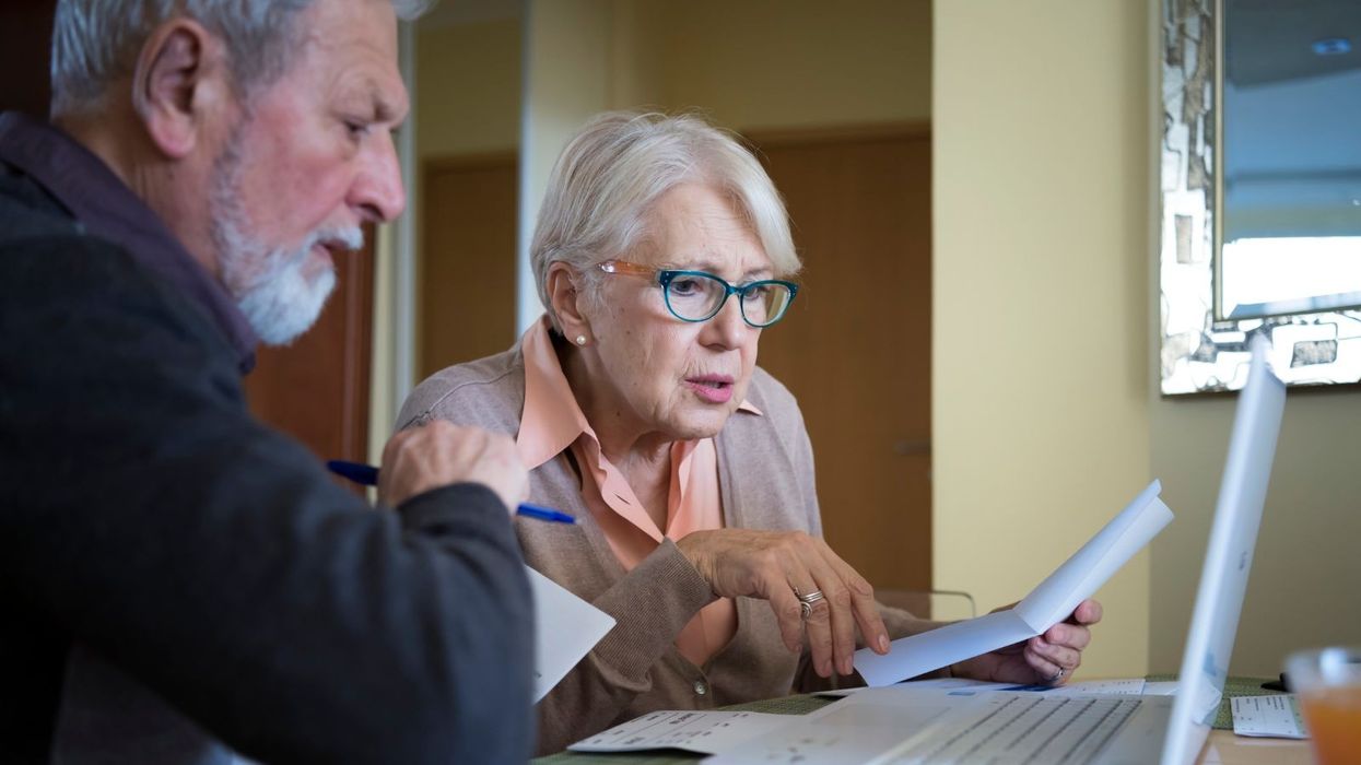 Pensioners look worried at letter and laptop
