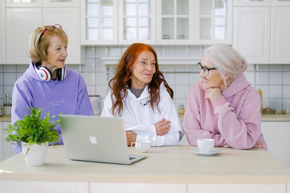Pensioners talking in front of laptop