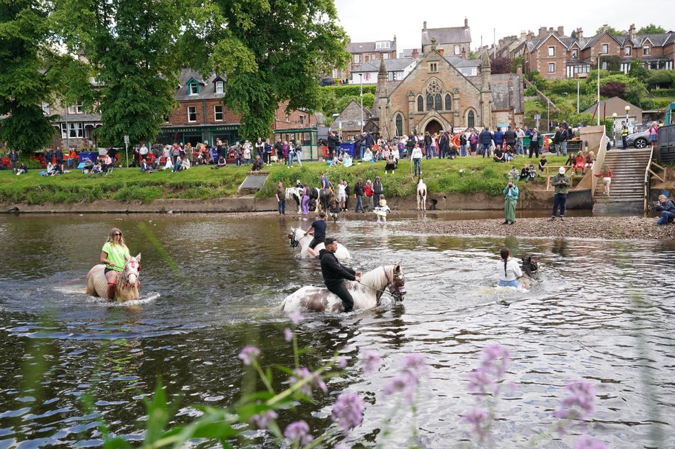 People and horses in the river at the Appleby Horse Fair, the annual gathering of the travelling community in Appleby