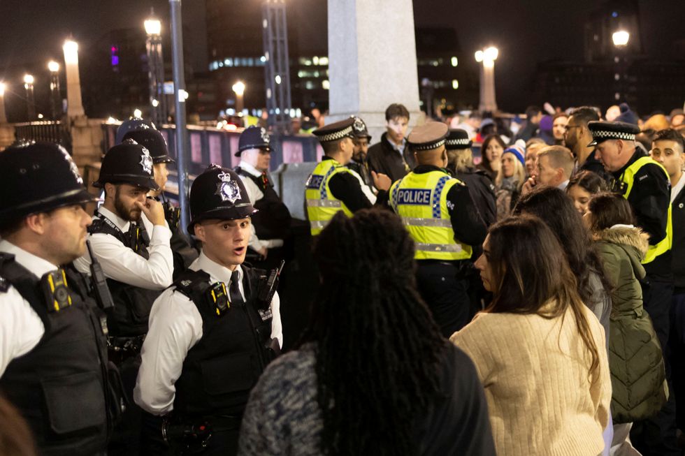 People argue with police officers after the door to pay respect to Britain's Queen Elizabeth was closed, following her death, outside of the Houses of Parliament in London, Britain September 18, 2022. REUTERS/Carlos Barria