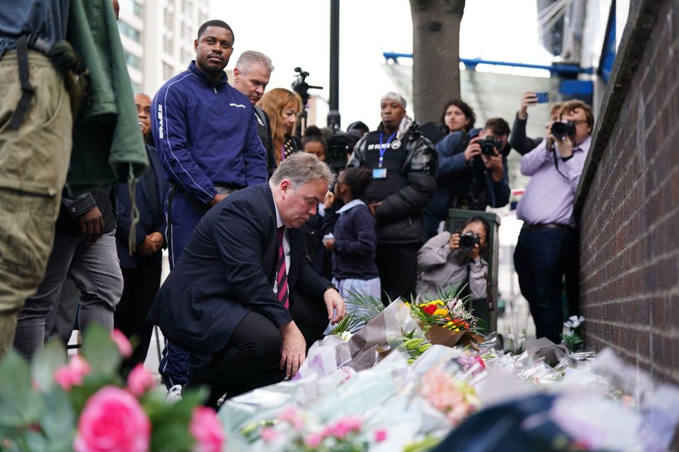 People arrive to lay flowers at the scene in Croydon